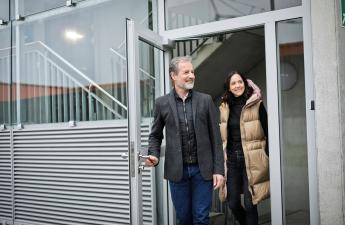 Personen verlassen gemeinsam durch eine Glastür ein Parkhaus